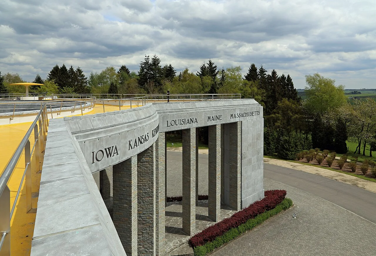 Mardasson Memorial in Bastogne met de namen van Amerikaanse staten in de stenen muur onder een bewolkte Ardennense hemel
