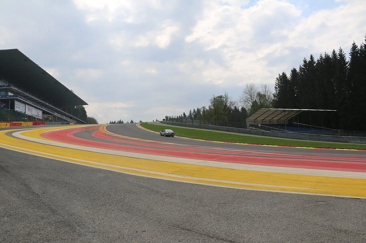 La Source-bocht bij de startfinish op Circuit de Spa-Francorchamps met de iconische rood-geel-zwarte randstenen en hoofdtribune