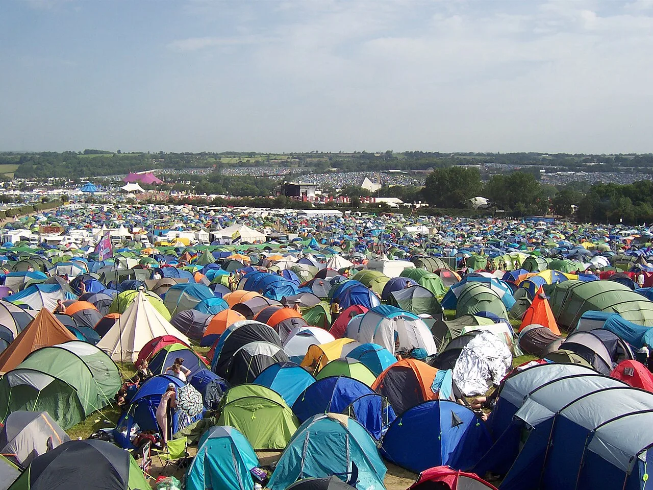 Uitgestrekt campingveld vol kleurrijke tenten bij een groot outdoor evenement