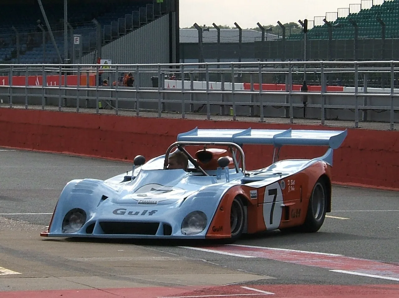 Klassieke Gulf Mirage GR7 racewagen op een circuit, symbool voor historisch racen