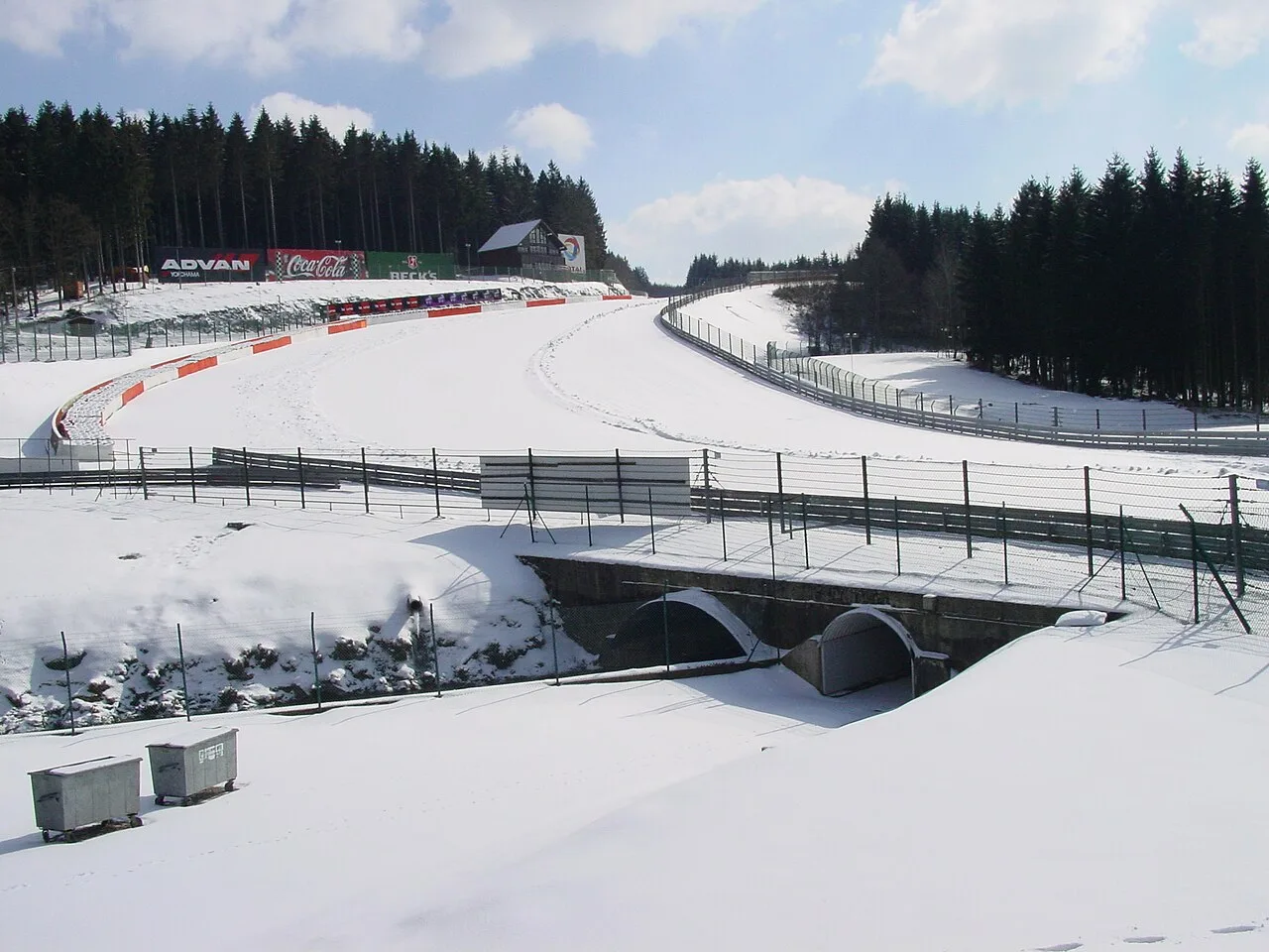 Circuit de Spa-Francorchamps bij Eau Rouge volledig bedekt met sneeuw in de winter, met dennenbomen op de achtergrond